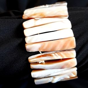 Cuff  Bracelet made of shells.  Mother of Pearl type finish.  Expandable